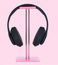 Black over-ear headphones on a pink headphone stand